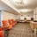 well lit hallway lined with tables and chairs leading to business center
