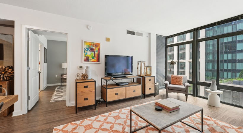 living room with natural light pouring in through large, floor-to-ceiling windows